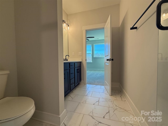 bathroom with baseboards, toilet, marble finish floor, and vanity