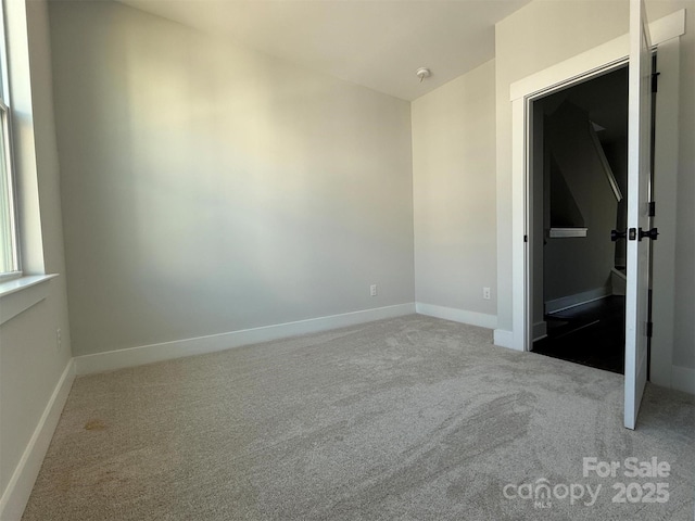 carpeted empty room with baseboards