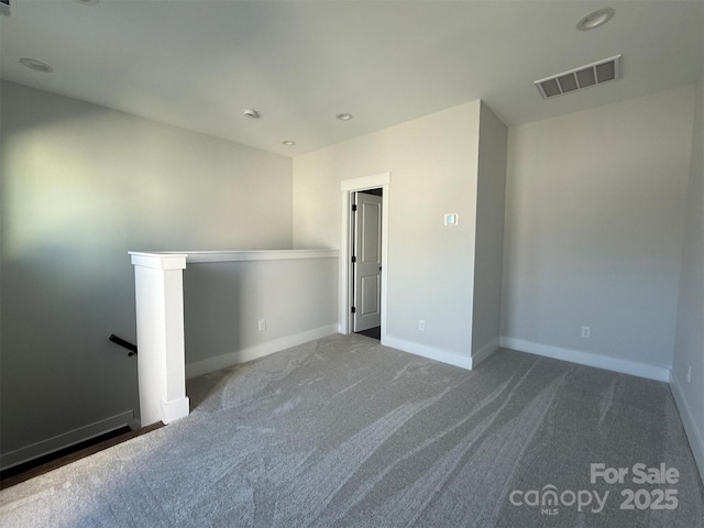 carpeted spare room featuring recessed lighting, visible vents, and baseboards