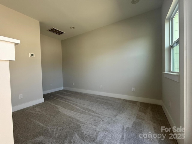 carpeted empty room featuring visible vents and baseboards