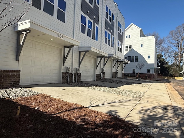 exterior space featuring brick siding, concrete driveway, and a garage