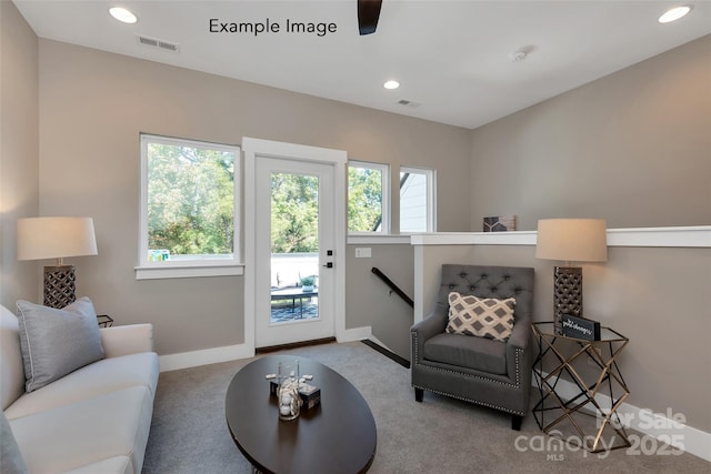 carpeted living room with visible vents, baseboards, and a healthy amount of sunlight