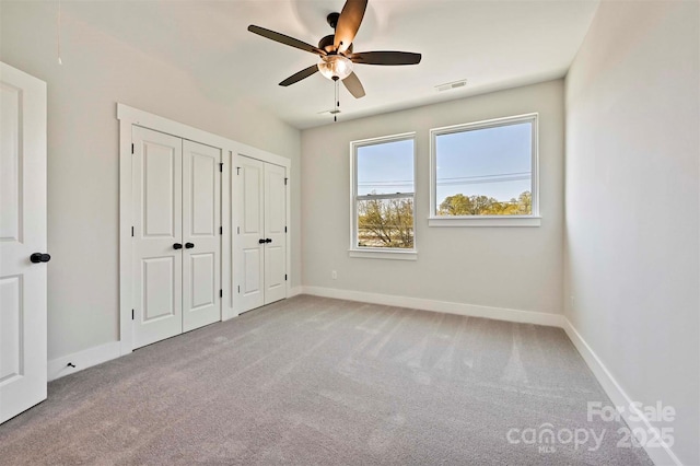 1227 E 34th St Unit Csw0420, Charlotte, NC 28205 - unfurnished bedroom with two closets, carpet, baseboards, and a ceiling fan