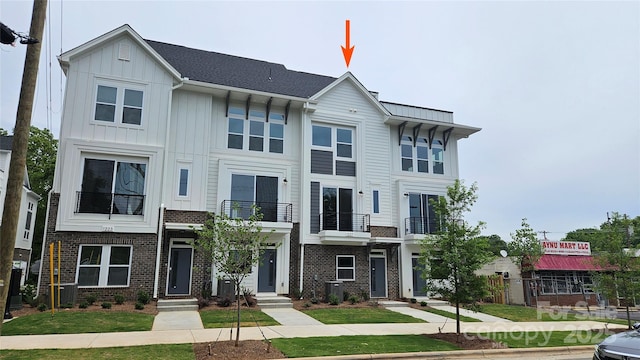 1227 E 34th St Unit Csw0420, Charlotte, NC 28205 - view of front of property with a balcony, central air condition unit, board and batten siding, brick siding, and a front lawn