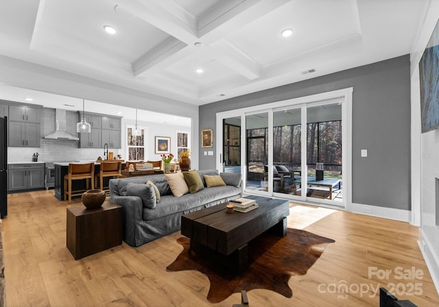 living room featuring coffered ceiling, beam ceiling, and light hardwood / wood-style floors