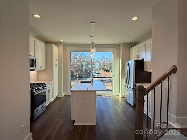 kitchen featuring white cabinets, sink, hanging light fixtures, and appliances with stainless steel finishes