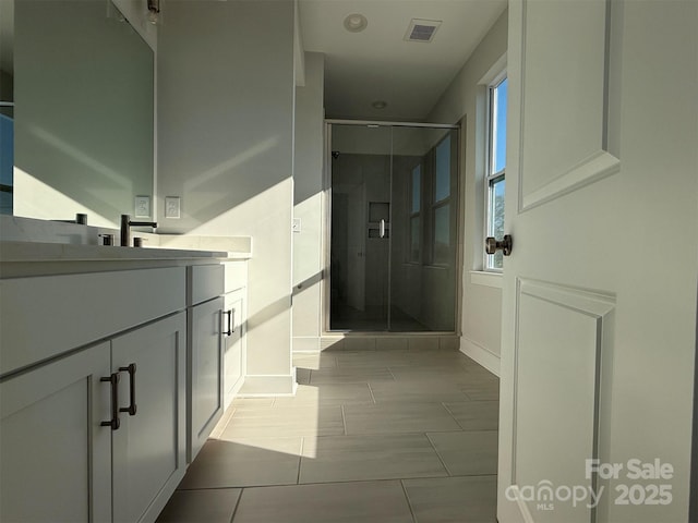 bathroom featuring tile patterned flooring, vanity, and walk in shower