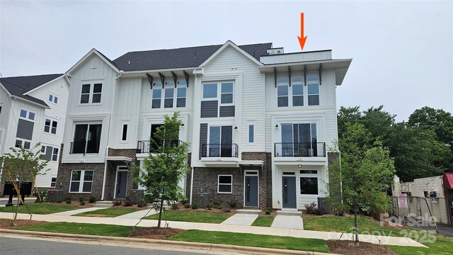 1229 E 34th St Unit Csw0421, Charlotte, NC 28205 - view of front of property featuring board and batten siding, central AC unit, brick siding, and a balcony