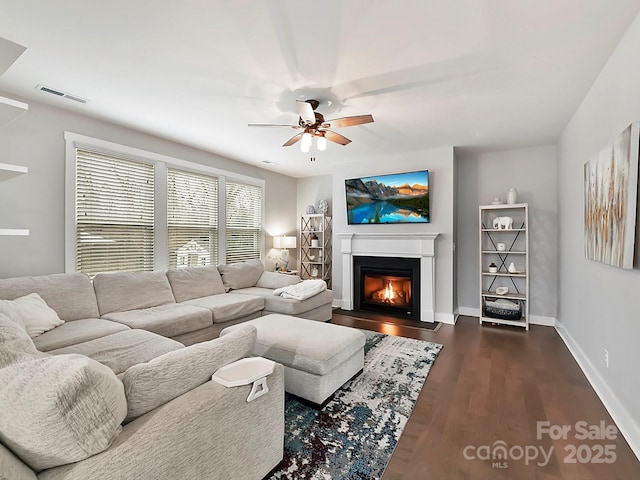 living room with ceiling fan and dark wood-type flooring