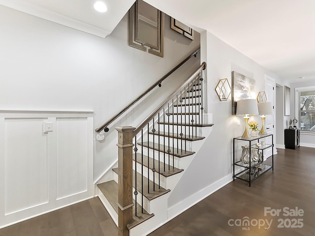 staircase featuring wood-type flooring and crown molding