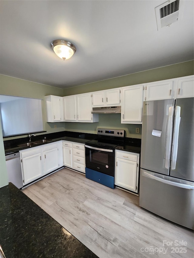 kitchen with white cabinets, sink, appliances with stainless steel finishes, and light hardwood / wood-style flooring