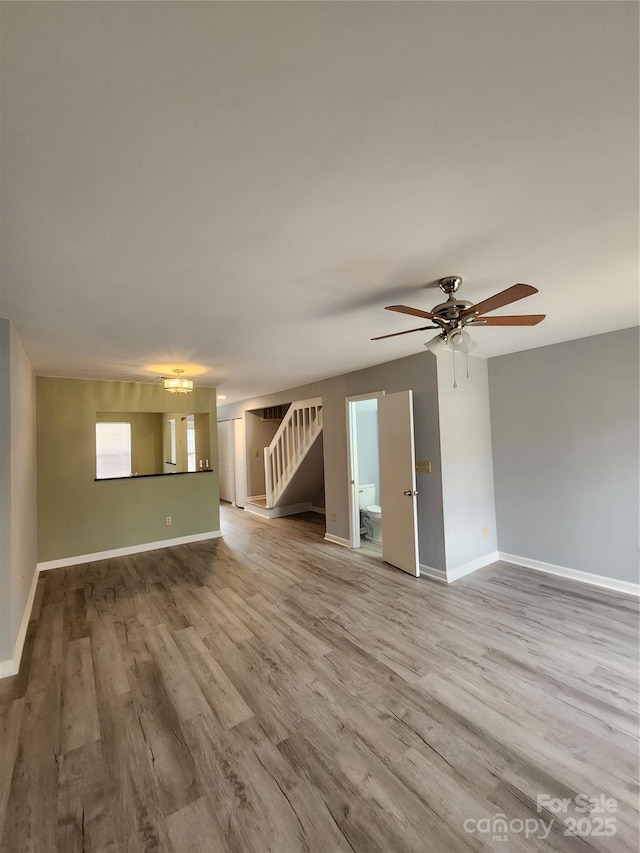 unfurnished living room featuring ceiling fan and light wood-type flooring