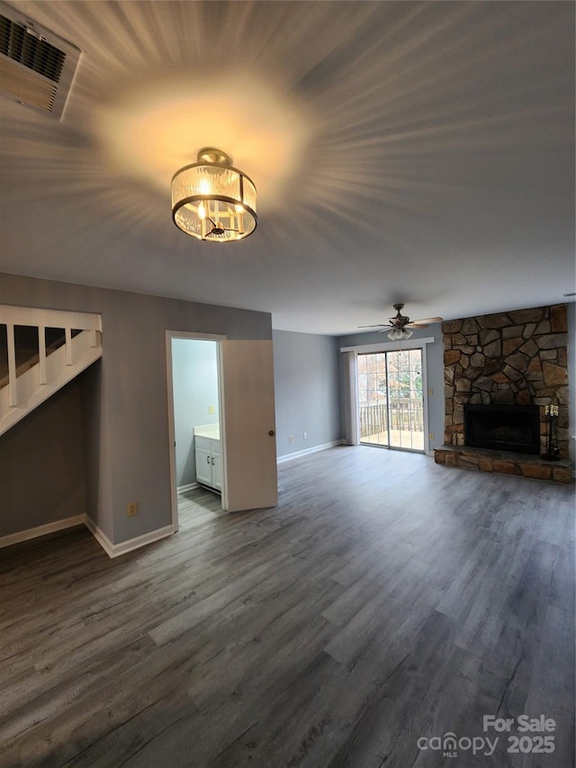 unfurnished living room featuring dark hardwood / wood-style flooring, ceiling fan, and a fireplace