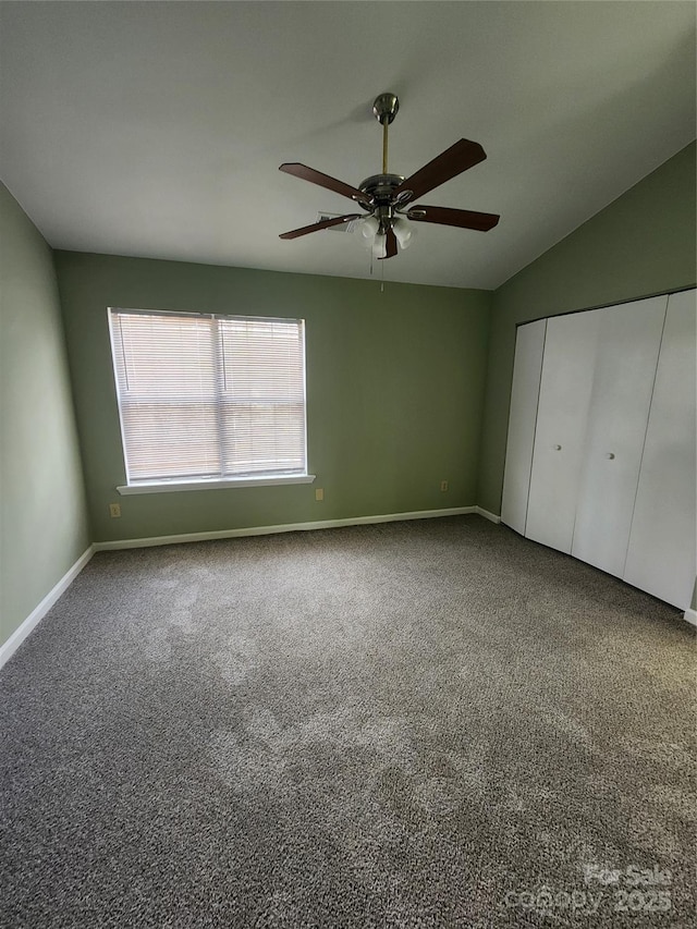 unfurnished bedroom with ceiling fan, a closet, carpet, and lofted ceiling