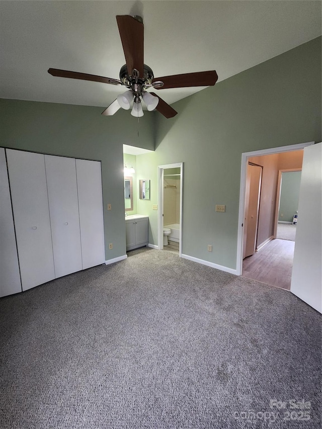 unfurnished bedroom with connected bathroom, ceiling fan, light colored carpet, and lofted ceiling