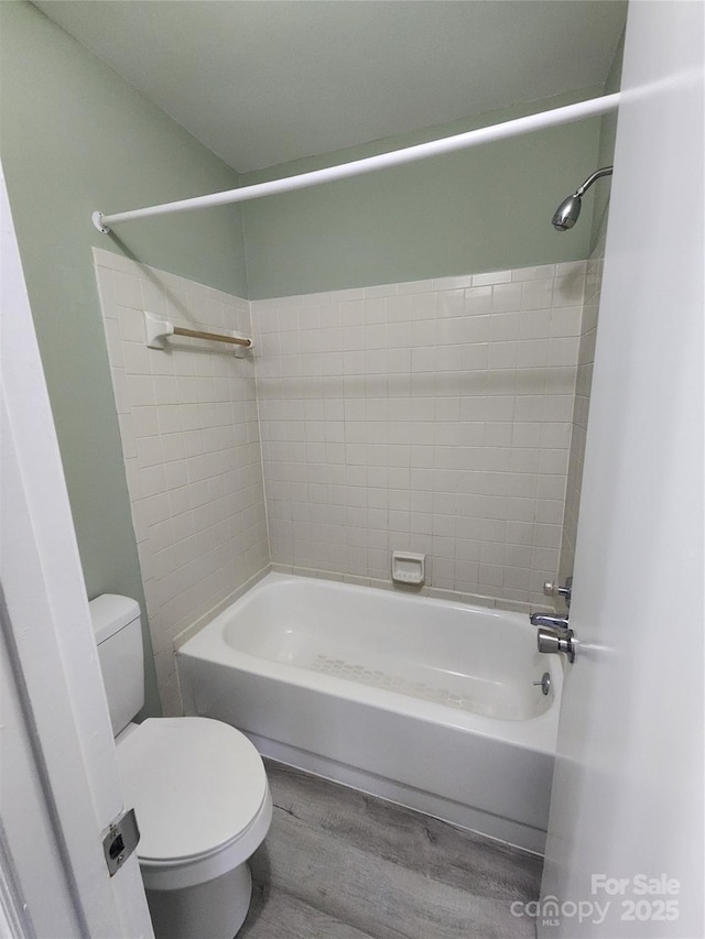 bathroom featuring wood-type flooring,  shower combination, and toilet