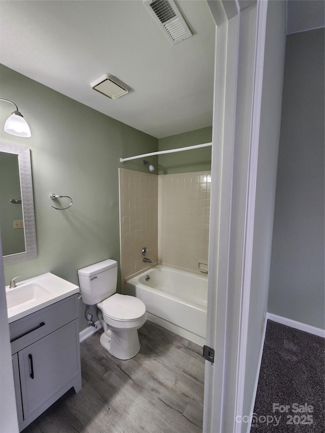 full bathroom with vanity, toilet, wood-type flooring, and tiled shower / bath