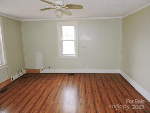 empty room featuring crown molding, dark hardwood / wood-style flooring, and ceiling fan