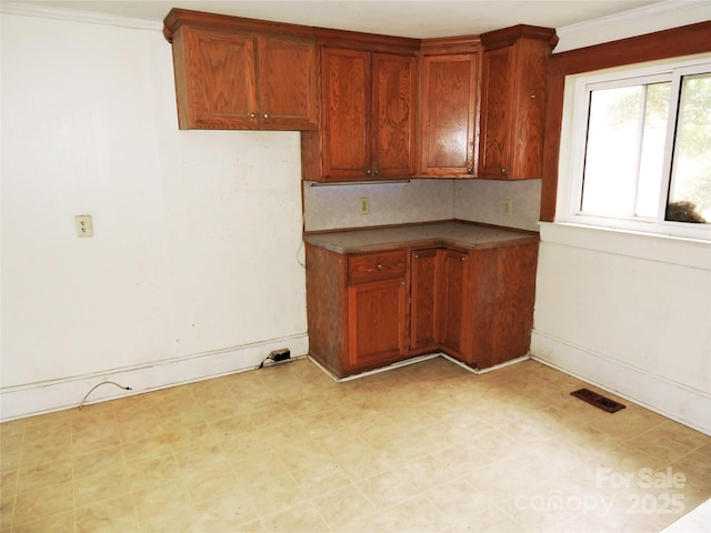 kitchen featuring decorative backsplash and ornamental molding