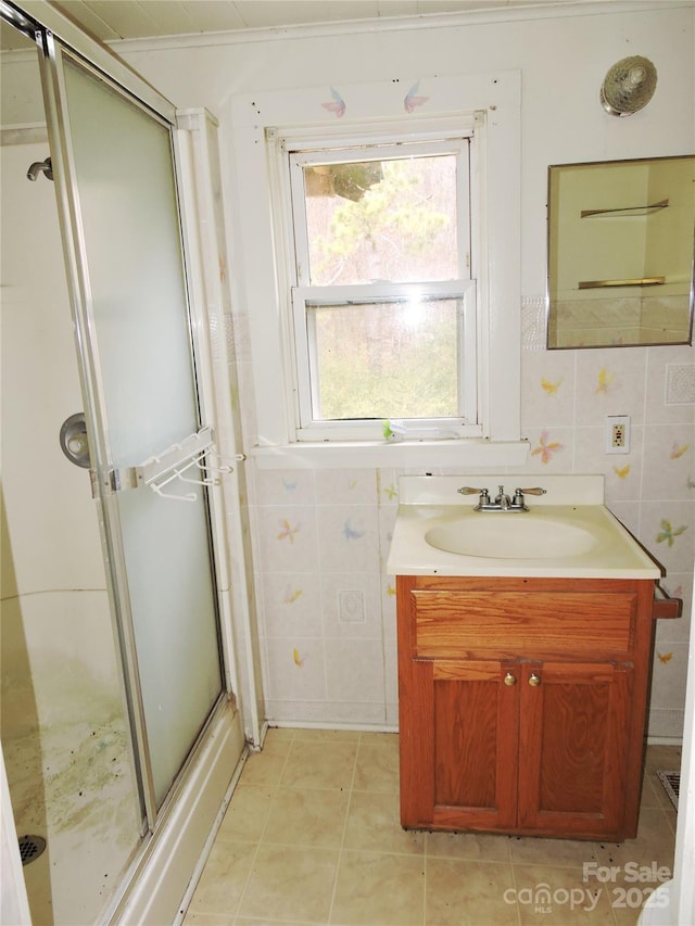 bathroom with an enclosed shower, vanity, tile walls, and crown molding