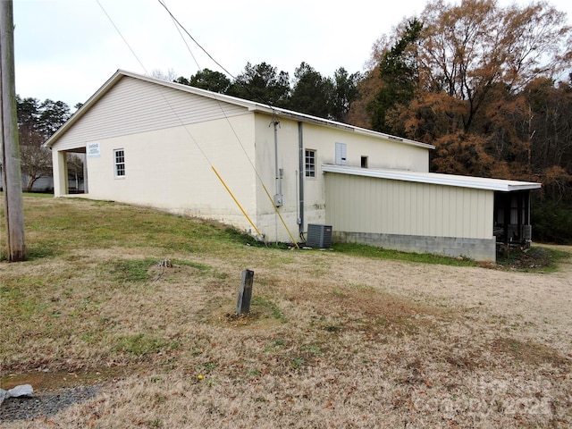 view of side of property with a yard and central AC unit