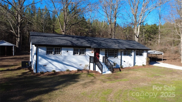 view of front of house with central AC unit, a front yard, and a carport