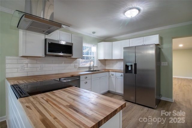 kitchen featuring wooden counters, appliances with stainless steel finishes, and white cabinets