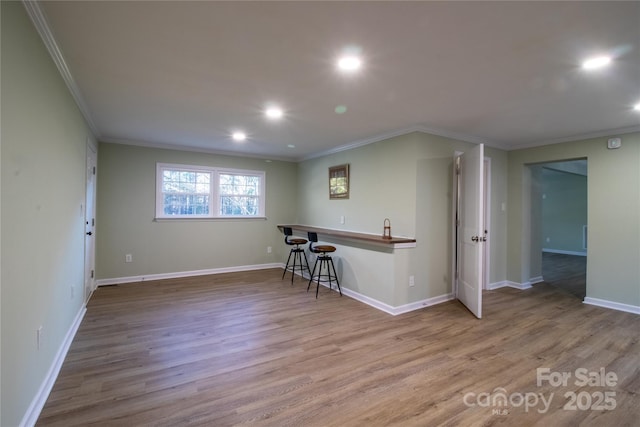 spare room featuring light wood-type flooring and crown molding