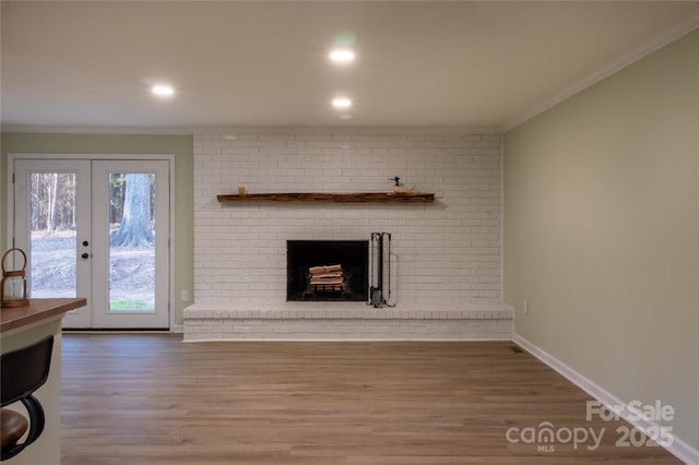 living room featuring a fireplace, french doors, hardwood / wood-style flooring, and ornamental molding