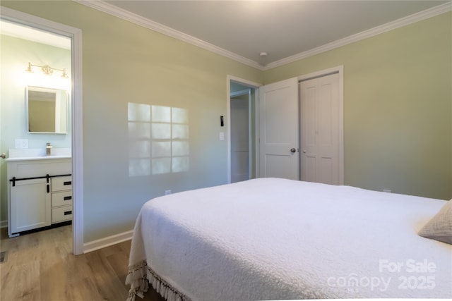 bedroom featuring light wood-type flooring, ensuite bath, and ornamental molding