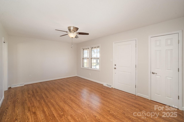 empty room with hardwood / wood-style floors and ceiling fan