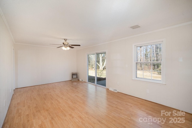 unfurnished room featuring heating unit, ceiling fan, crown molding, and light hardwood / wood-style flooring