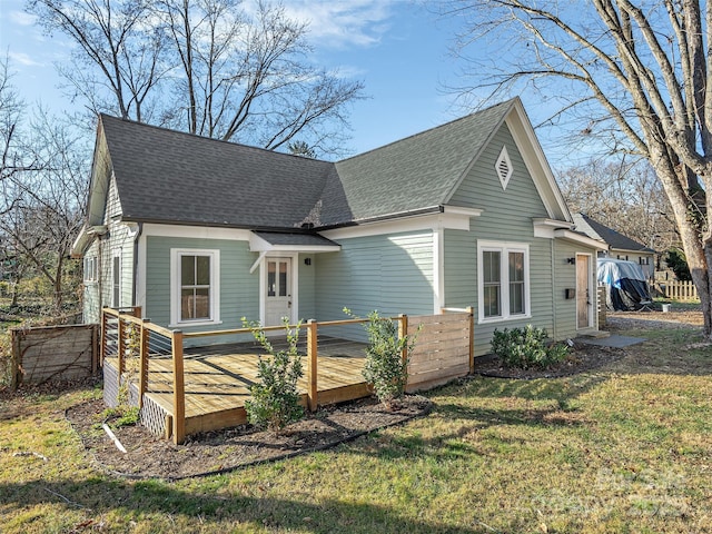 view of front of property featuring a wooden deck and a front lawn