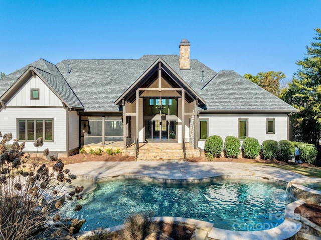 rear view of property featuring pool water feature and a patio