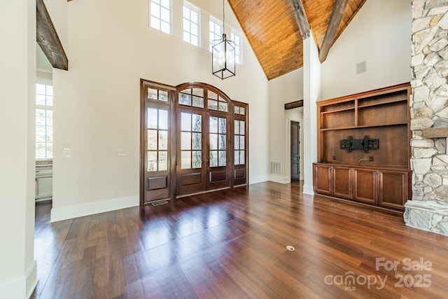 entrance foyer featuring dark wood-type flooring, beam ceiling, high vaulted ceiling, wooden ceiling, and french doors