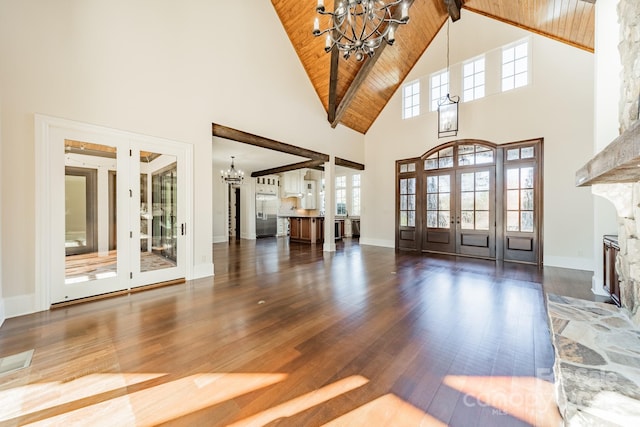 entrance foyer featuring an inviting chandelier, a fireplace, dark wood-type flooring, wooden ceiling, and beam ceiling