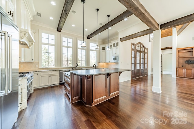 kitchen featuring backsplash, stainless steel appliances, a center island, and white cabinets