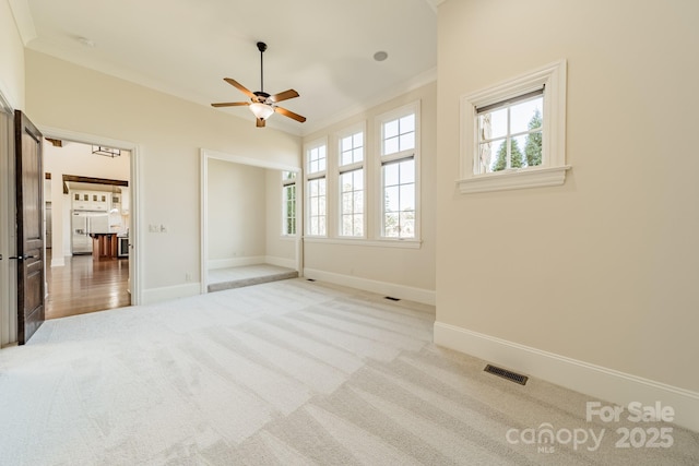 unfurnished bedroom with multiple windows, crown molding, and light carpet