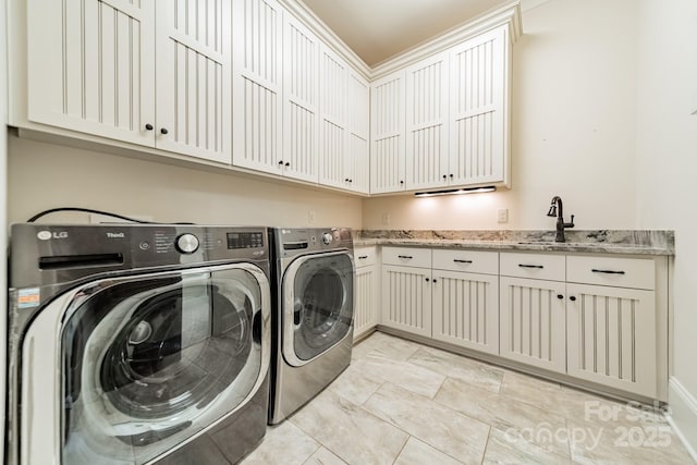 washroom featuring washer and dryer, sink, and cabinets