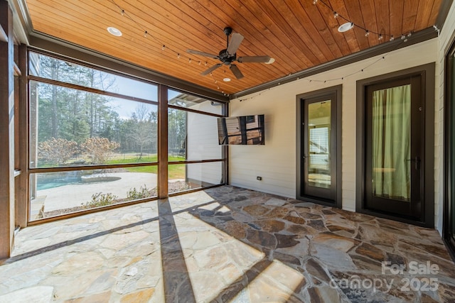 unfurnished sunroom with ceiling fan and wooden ceiling