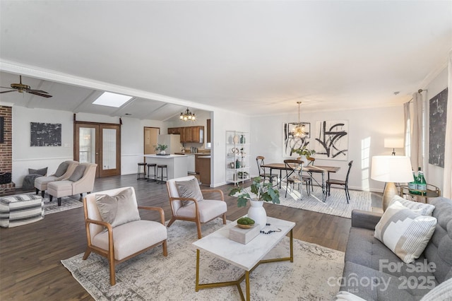 living room featuring ceiling fan with notable chandelier, dark hardwood / wood-style flooring, lofted ceiling with beams, and french doors