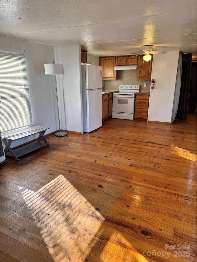 kitchen with hardwood / wood-style floors, white appliances, and a textured ceiling