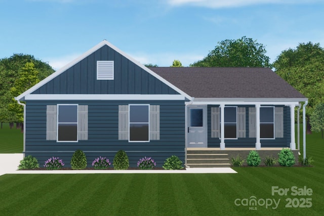 view of front of home with board and batten siding, a front yard, and roof with shingles