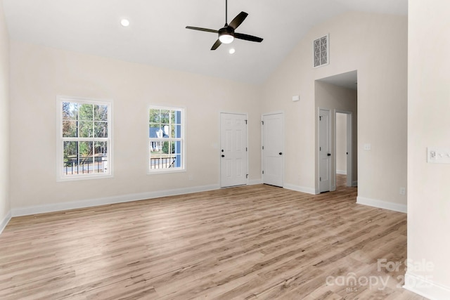 unfurnished living room with ceiling fan, high vaulted ceiling, visible vents, baseboards, and light wood-type flooring