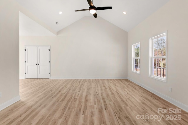 empty room with ceiling fan, high vaulted ceiling, light wood-style flooring, recessed lighting, and baseboards