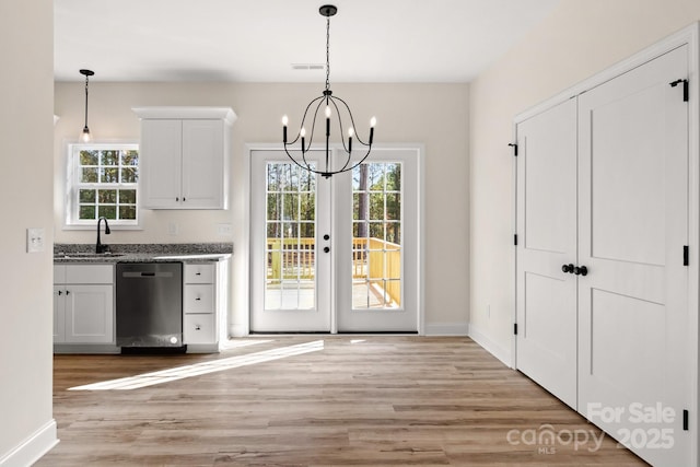 interior space with light wood-type flooring, plenty of natural light, visible vents, and a sink