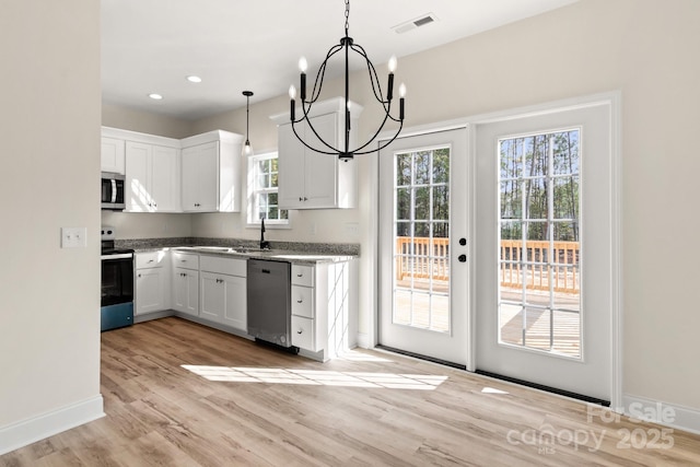 kitchen featuring pendant lighting, a notable chandelier, light wood finished floors, appliances with stainless steel finishes, and white cabinets