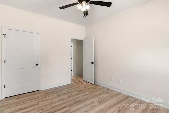 unfurnished bedroom with light wood-style floors, ceiling fan, and baseboards