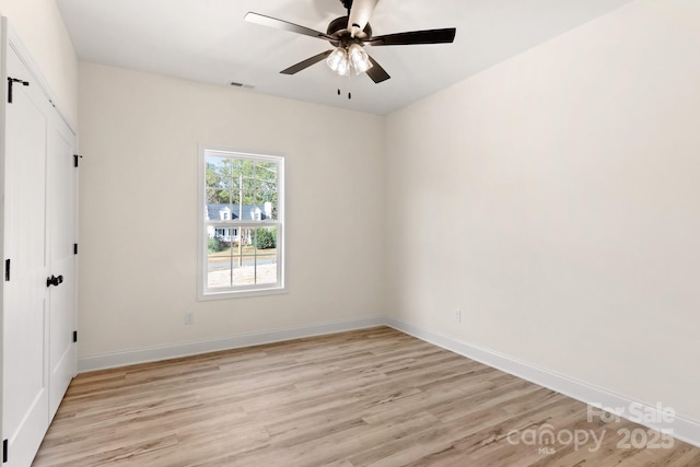 unfurnished room with light wood-type flooring, visible vents, ceiling fan, and baseboards