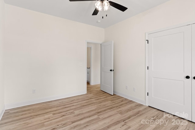 unfurnished bedroom featuring ceiling fan, light wood-style flooring, and baseboards